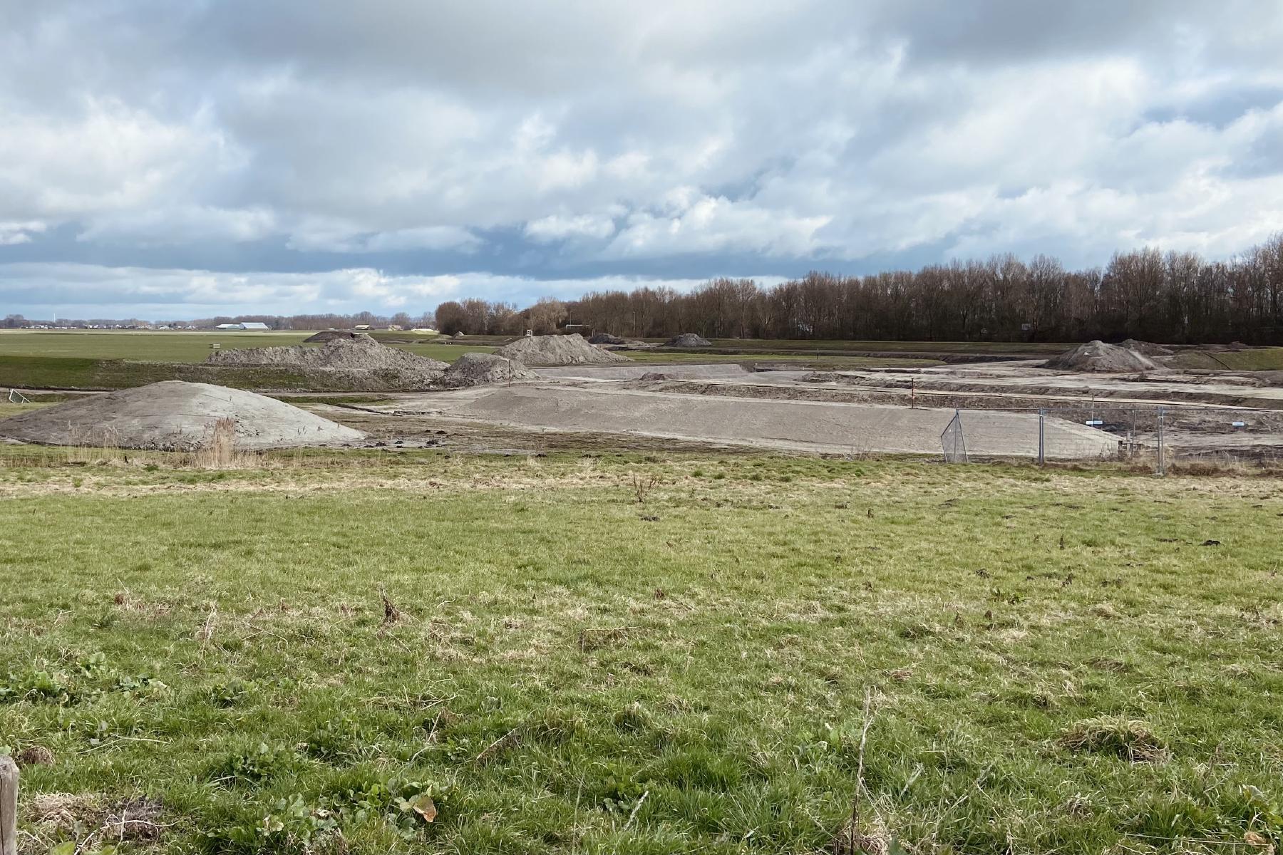 an image of several dikes under construction, earthen mounds